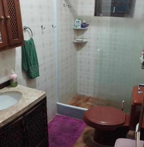a bathroom with a shower with a toilet and a sink at Suíte da Lagoa in Araruama