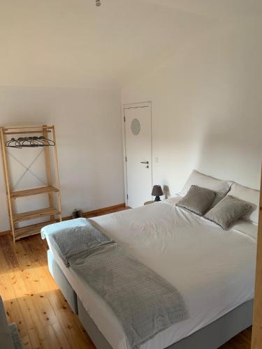 a bedroom with a large white bed and a ladder at Casa Picobello in Calheta de Nesquim