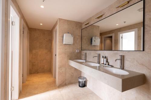 a bathroom with two sinks and a large mirror at Jeroom Hostel in Jerusalem