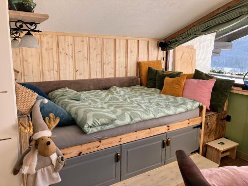 a bed in a room with a wooden wall at Dachstein Stüberl in Bad Aussee
