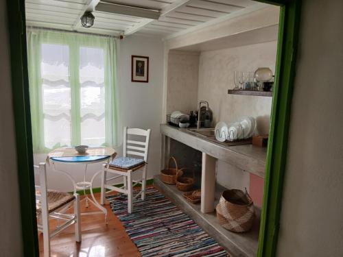 a kitchen with a table and a table and chairs at Aegaia Residencies in Katapola