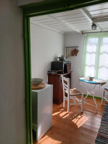 a living room with a table and a kitchen at Aegaia Residencies in Katapola