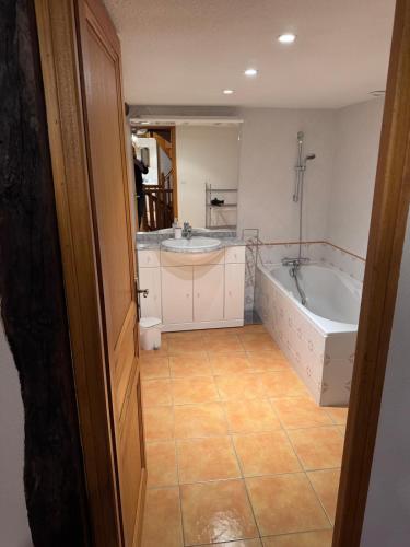 a bathroom with a tub and a sink and a bath tub at Le relais de Lustrande in Brezons