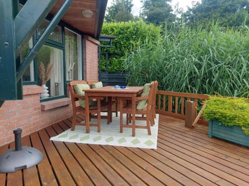 a wooden table and chairs on a deck at Ferienwohnung Nordholland in Nieuwe-Niedorp
