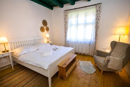 a bedroom with a bed and a chair and a window at DOM na konci in Kostolné