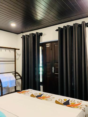 a bedroom with black drapes and a bed at D2 Villa in Tangalle