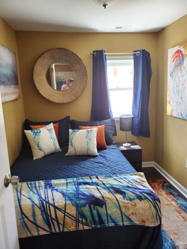 a bedroom with a bed with blue sheets and a mirror at The Bay House in Shady Side