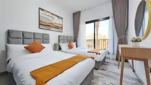 a hotel room with two beds and a desk at Family Friendly Villa in Abu Dhabi