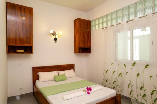 a small bedroom with a bed and a window at Maison d'hôte Chez Vané in Sambava