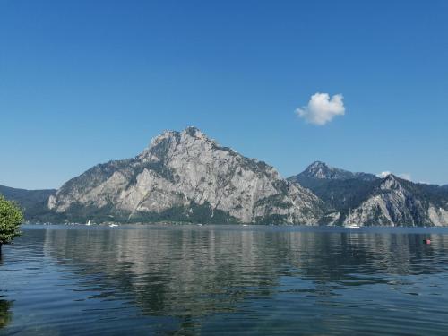 a view of a mountain from a lake at dastraunseehaus in Traunkirchen