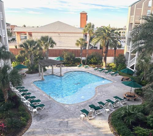 an overhead view of a pool with chaise lounge chairs and a resort at Boltons Bungalow Casa Del Mar in Galveston