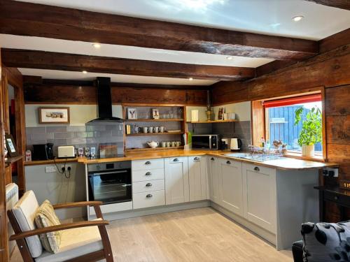 a large kitchen with white cabinets and a window at Cosy coastal hideaway with incredible sea views in Fortrose