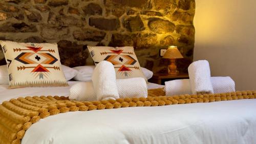 a bedroom with two beds and a stone wall at Apartamentos rurales La Pornacal I y La Pornacal II in Villar de Vildas