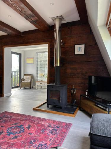 a living room with a fireplace and a tv at Cosy coastal hideaway with incredible sea views in Fortrose
