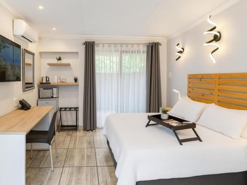 a hotel room with a bed and a desk at Echo Mountain Inn in Thabazimbi