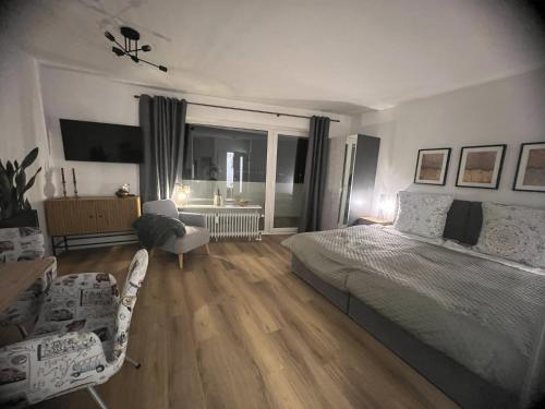 a bedroom with a bed and two chairs in it at Bella Vista Studio-Appartement in Bad Rothenfelde