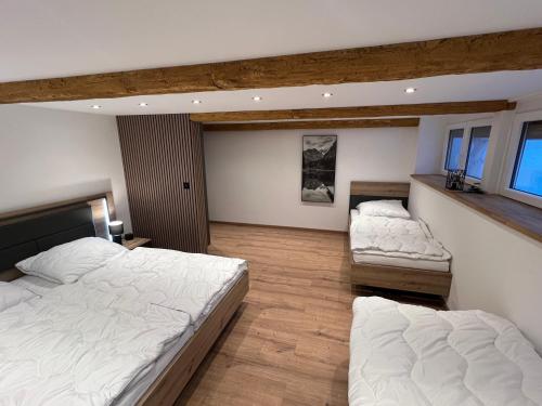 two beds in a large room with twothirds at Fichtelrooms in Fichtelberg