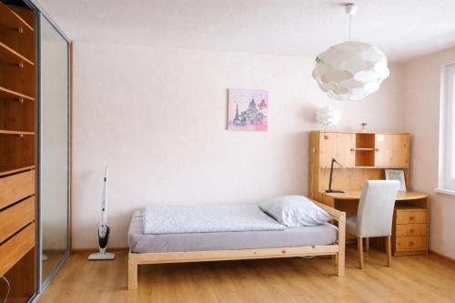 a bedroom with a bed and a desk and a lamp at Apartmán Levice in Levice