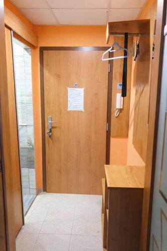 a bathroom with a wooden door with a sign on it at Apartmán Levice in Levice
