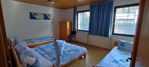 a small room with two beds and two windows at Apartmány Anna s welness in Trojanovice