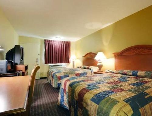 a hotel room with two beds and a television at Americas Best Value Inn Yukon in Yukon