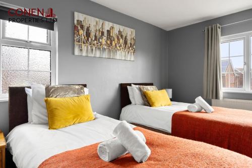 a bedroom with two beds with stuffed animals on them at CONEN Morant Place in Grays Thurrock