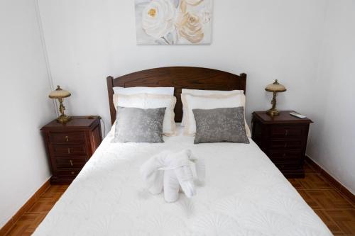 a bedroom with a white bed with two night stands at Casa 'Saudade' in Moura