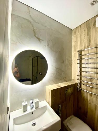 a bathroom with a sink and a mirror at Modern 3-bedroom jacuzzi apartment in Lviv