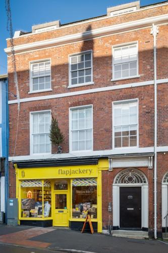 a yellow store front of a brick building at Stylish Retreat in Central Lyme Regis Sleeps 2 plus one in Lyme Regis