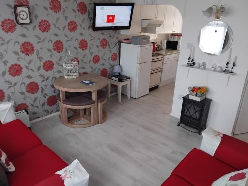 a living room with a table and a kitchen at "Trinity" Chalet in Sundowner Hemsby in Hemsby