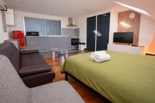a hotel room with a bed and a couch at Tarleton Guesthouse in Stoke on Trent