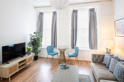 a living room with a couch and a tv at Stylish Retreat in Central Lyme Regis Sleeps 2 plus one in Lyme Regis