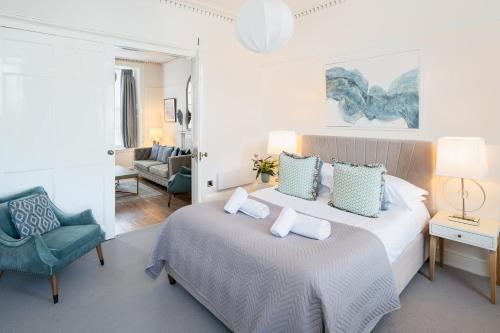 a hotel room with a bed and a chair at Stylish Retreat in Central Lyme Regis Sleeps 2 plus one in Lyme Regis