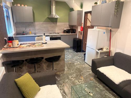 a kitchen with a counter and a kitchen with a refrigerator at Tarleton Guesthouse in Stoke on Trent