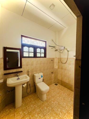 a bathroom with a toilet and a sink at Asiri guest house in Dickwella