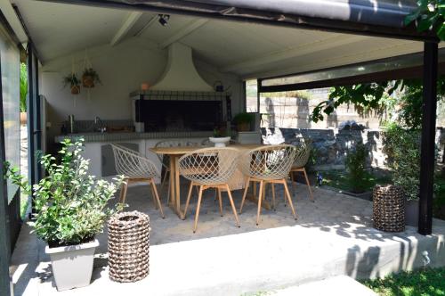 a patio with a table and chairs in a kitchen at "LaGo Village House" Family & Group Retreat near Meteora in Kalabaka