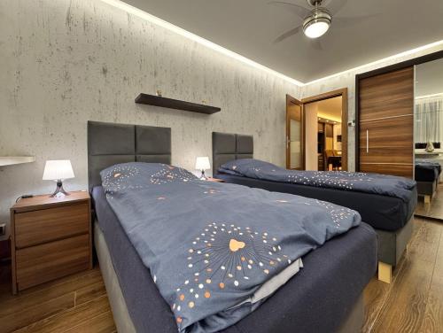 two beds with blue sheets in a room at Apartament Palisadowa 78 in Wałbrzych