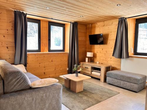a living room with a couch and a tv at Appartement Chalet Louison in Les Gets