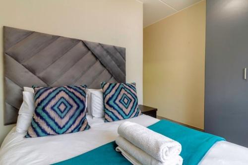 a bedroom with a bed with towels on it at The Waterfallcity Charm next to Mall of Africa in Midrand