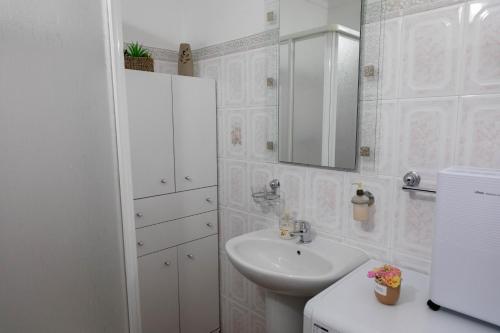 a white bathroom with a sink and a mirror at Casa 'Saudade' in Moura