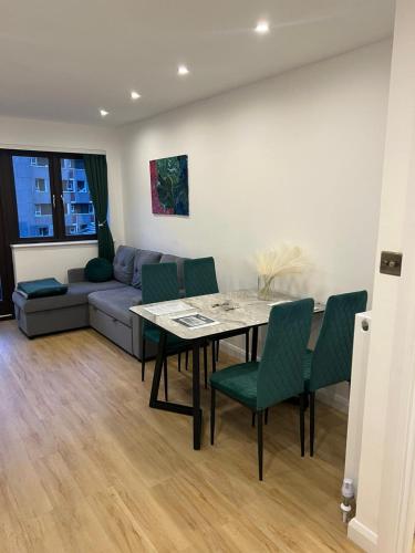 a living room with a table and green chairs at Shoreditch Dream in London