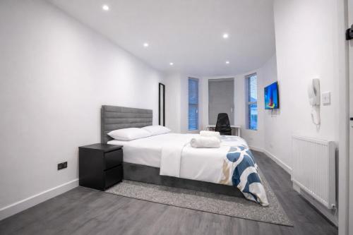 a white bedroom with a bed and a desk at Seamflow Homes - Folkestone, near Eurotunnel - Channel Tunnel in Folkestone