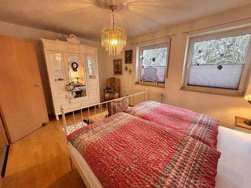 a bedroom with a bed and a chandelier and windows at Vintage Traum in Hückelhoven