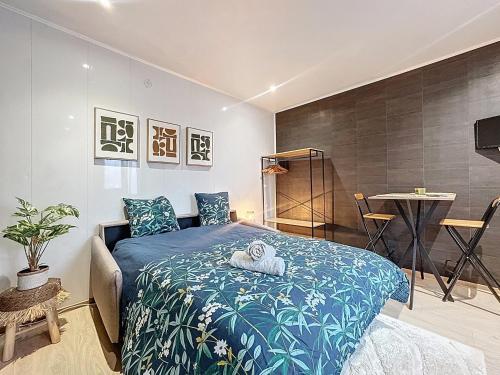 a bedroom with a blue bed with a towel on it at Cosy & Charmant - centre et tranquillité in Erstein