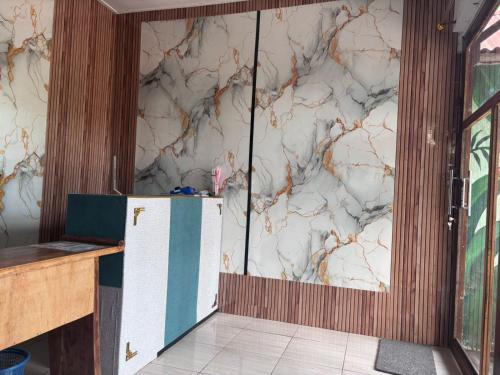 a kitchen with a marble wall with a refrigerator at Sony massage in Gili Trawangan