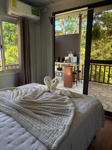 a bedroom with a bed with towels on it at Cabaña BosKaL in Quesada