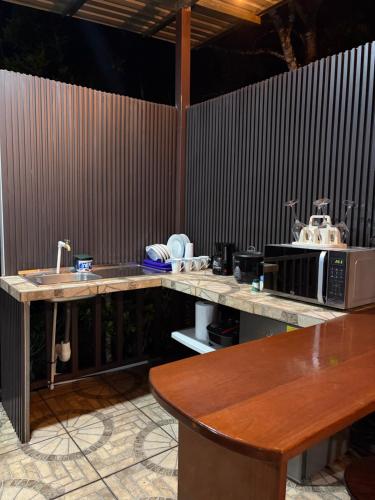 a kitchen with a counter with a microwave and a table at Cabaña BosKaL in Quesada