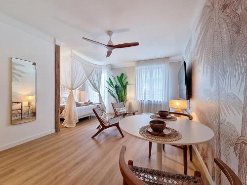 a living room with a table and a bedroom at La Suite BALI, Charme et Confort, Hyper centre in La Roche-sur-Yon