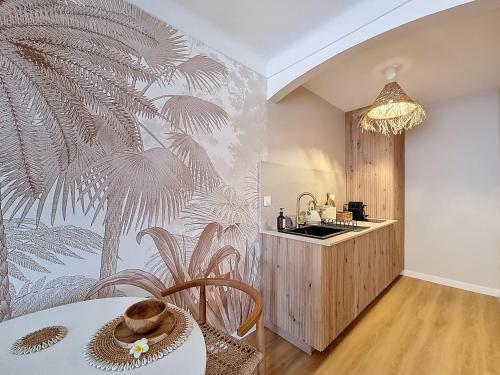 a bedroom with a tropical wallpaper on the wall at La Suite BALI, Charme et Confort, Hyper centre in La Roche-sur-Yon