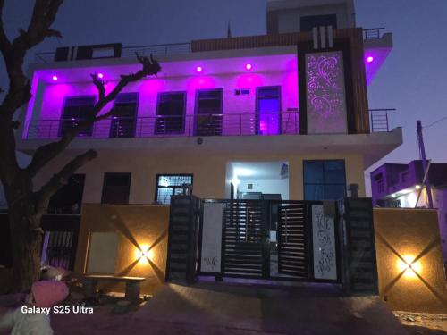 a building with purple lights on it at night at Red diamond palace in Sīkar